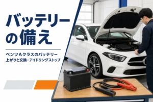 ボンネットを開けたハッチバックと、作業台に置いた新しいバッテリーとジャンプケーブル